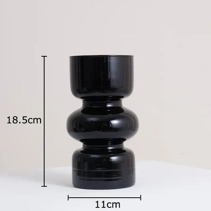 DecorBites black glass vase with stacked rounded segments and artificial flowers for minimalist room decor