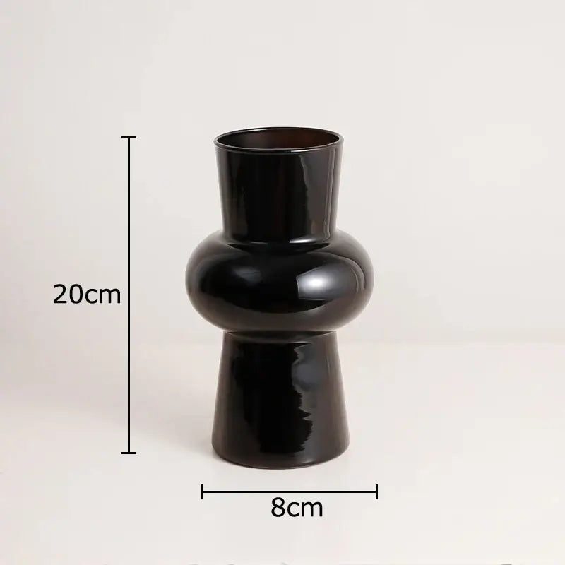A sleek decorbites black glass vase with a narrow neck and artificial flowers for minimalist room decor