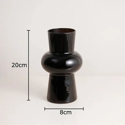 A sleek decorbites black glass vase with a narrow neck and artificial flowers for minimalist room decor