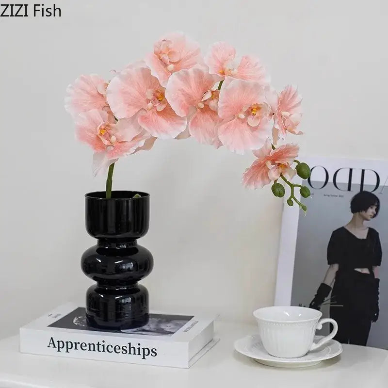 Decorbites black glass vase with stacked segments holding delicate pink artificial flowers for minimalist decor