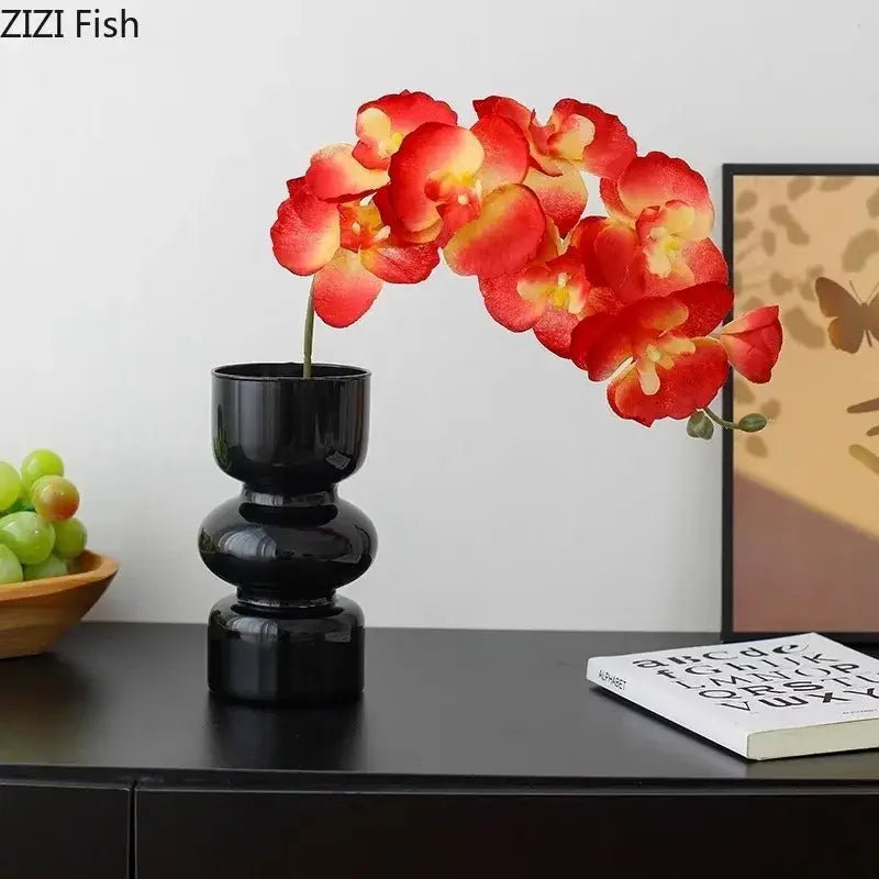 Decorbites black glass glossy ceramic vase with stacked tiers holding vibrant red and yellow artificial flowers