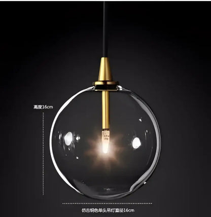 Clear glass globe pendant light with black gold brass fixture and hanging cord from decorbites black gold chandelier