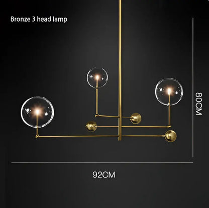 Bronze three-head lamp with clear glass globe shades and polished black gold brass arms by decorbites black gold
