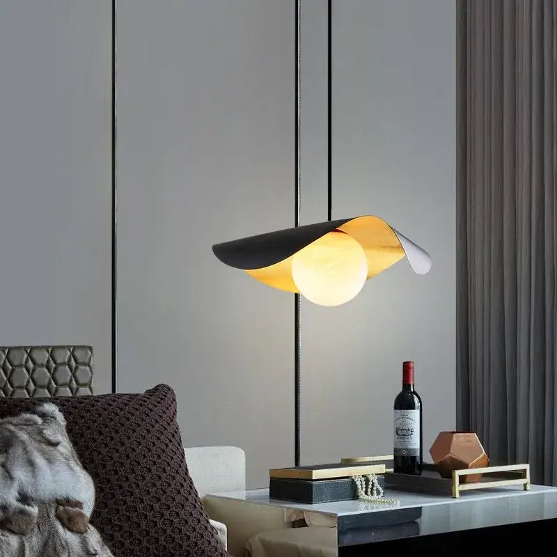 Decorbites black gold pendant light with sleek black and gold leaf-shaped glass shade and illuminated spherical bulb