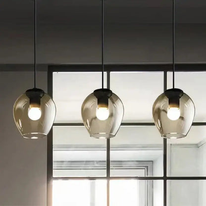 Three hanging pendant wall lamps with translucent amber glass globes and black gold metal fixtures by decorbites black gold