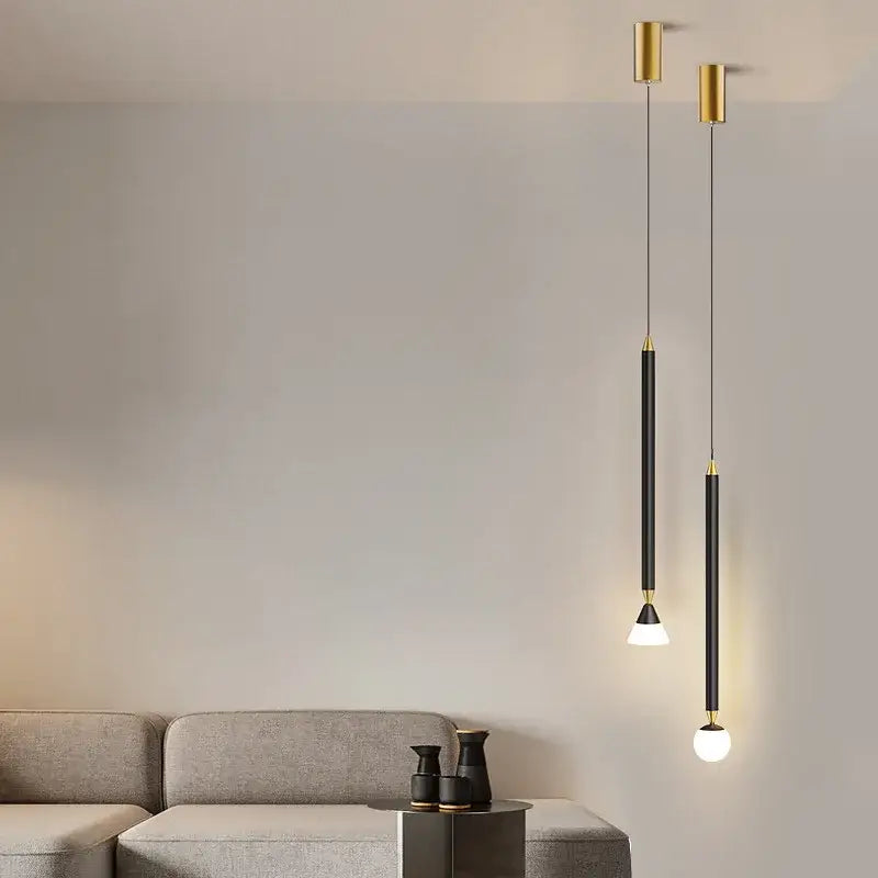 Two minimalist DecorBites black gold pendant lights with frosted glass globes and black matte rods for bedroom sconces