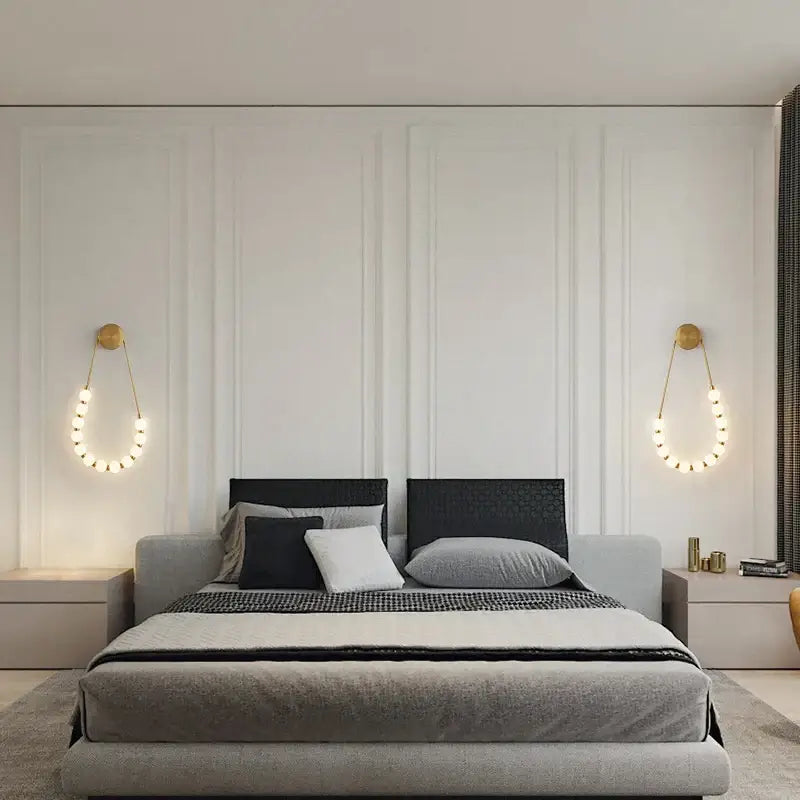 Modern gray upholstered bed with black textured headboard and layered pillows beside decorbites black gold led wall lamp sconce