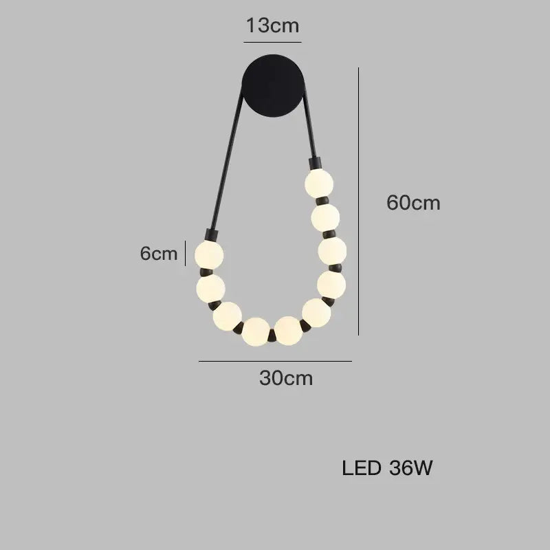 DecorBites black gold led wall lamp features cream spherical bulbs on black cords in an elegant teardrop shape