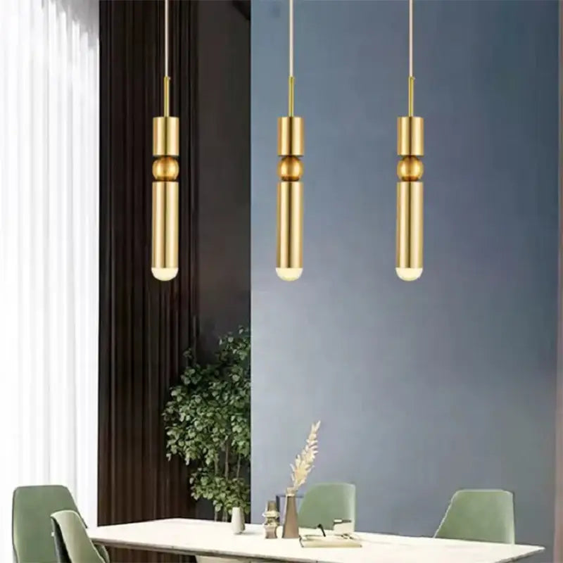 Three sleek decorbites black gold led tube pendant lamps with polished gold finish and cylindrical glass design hanging from ceiling