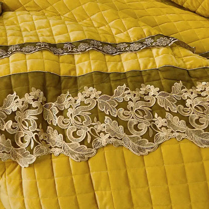A cream lace trim with floral patterns stitched on quilted mustard yellow fabric in decorbites black gold luxury bedding set