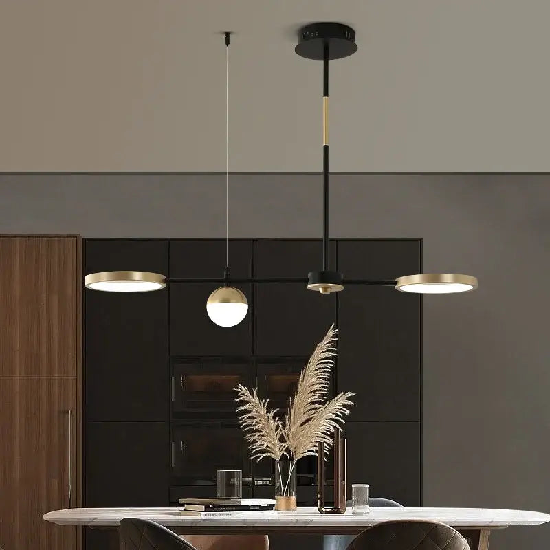 Modern black gold minimalist chandelier featuring three illuminated heads in decorbites black gold design for dining room decor