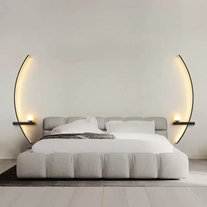 Modern gray upholstered bed with tufted headboard flanked by decorbites black gold modern wall sconce emitting warm light