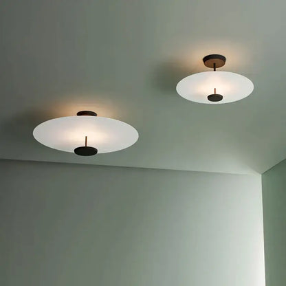 Two minimalist ceiling lights with frosted glass shades and dark bronze fixtures in decorbites black gold round chandelier
