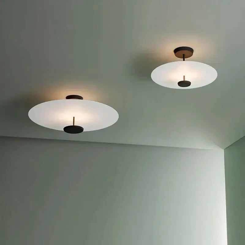 Two minimalist ceiling lights with frosted glass shades and dark bronze fixtures in decorbites black gold round chandelier