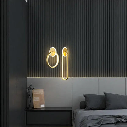 Gold-toned minimalist wall sconces with modern ring and elongated oval design complement decorbites black gold pendant light