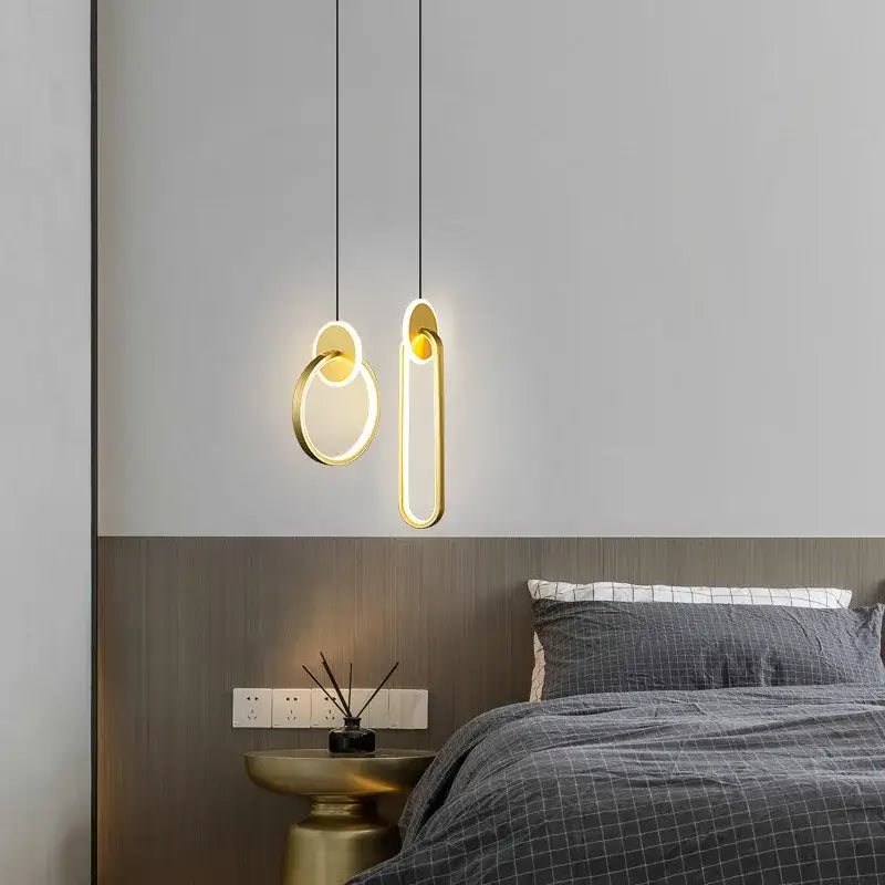 Modern gold-toned DecorBites black gold round pendant light with sleek geometric design hanging above a bed