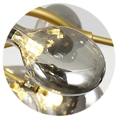 A sleek glass pendant light with gold-toned metal base and filament bulb for decorbites black gold tree branch chandelier