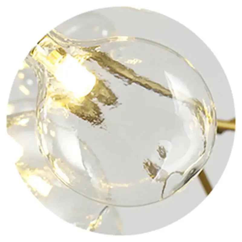 Clear glass globe with gold-toned internal wiring and warm light in decorbites black gold tree branch chandelier
