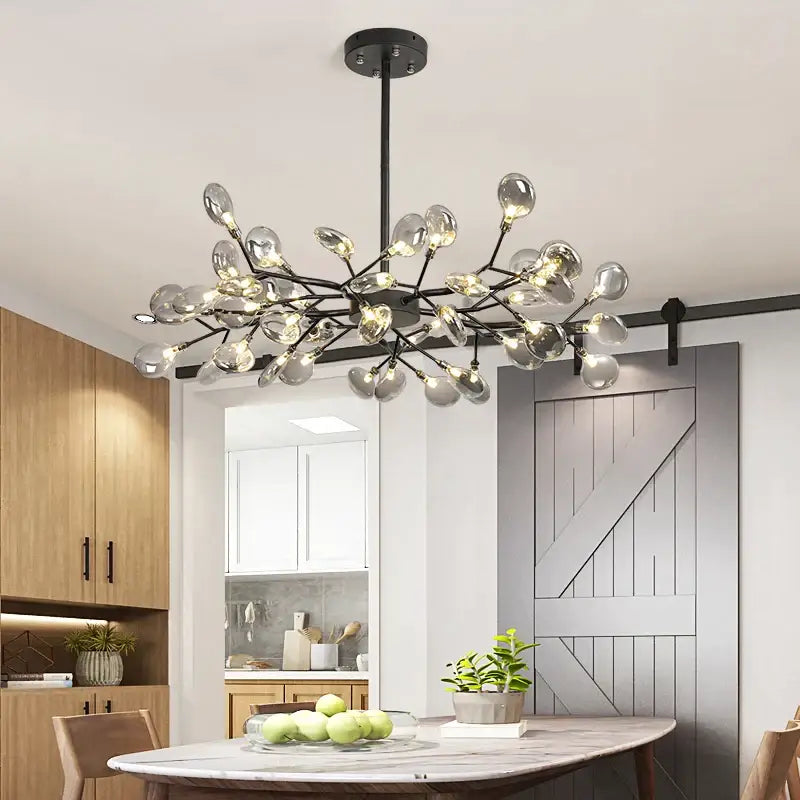 Modern black gold metal chandelier with clear glass globe bulbs in a tree branch design by DecorBites black gold