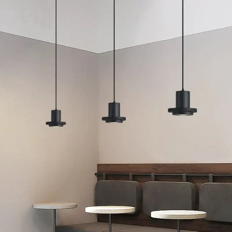 Three sleek black cylindrical pendant lights with matte finish in the decorbites black hole stone chandelier design