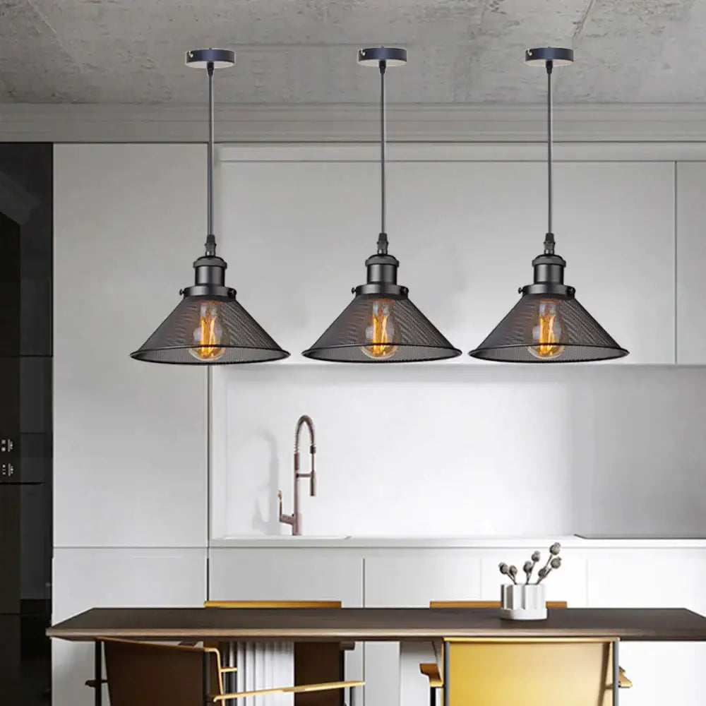 Three black iron cage pendant lights with mesh shades and exposed filament bulbs hang above a kitchen island