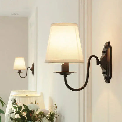 Antique bronze-finished decorbites black iron wall lamp with cream fabric shade for elegant rural bedroom and living room