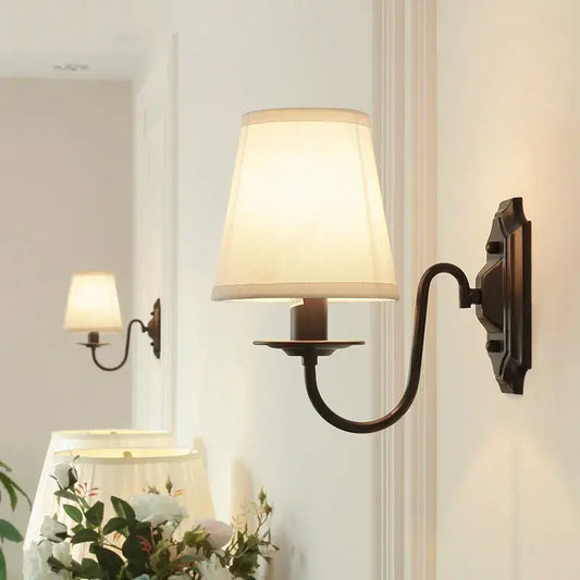 Antique bronze-finished decorbites black iron wall lamp with cream fabric shade for elegant rural bedroom and living room
