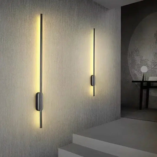 Two sleek decorbites black led wall lights with slender metallic rods and warm yellow light for modern indoor décor