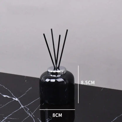 Black glass reed diffuser with silver metallic cap and five black reeds from decorbites black marquina bathroom set