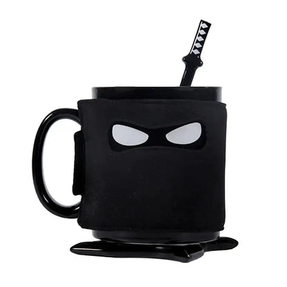 A decorbites black ninja mug with matte finish and white eye cutouts featuring a matching black sword stirrer