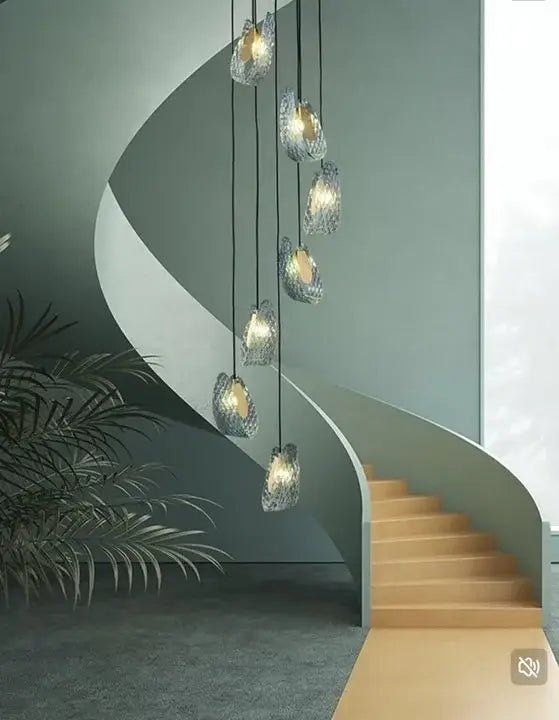 A modern cascading chandelier with blue glass led pendant lamps featuring textured frosted glass and warm interior lighting
