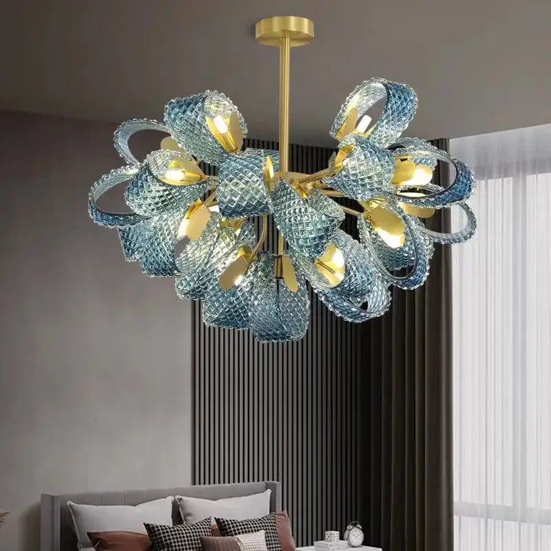 A modern decorbites™ blue glass led pendant lamp featuring intricate blue glass petals and gold-toned metal accents