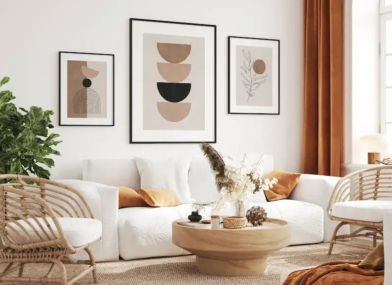 White sectional sofa with orange throw pillows next to decorbites bohemian geometric plant wall art set