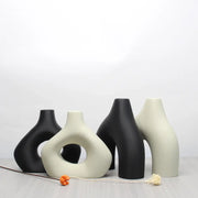 Set of four minimalist black and off-white ceramic vase set with abstract shapes for bohemian home decor