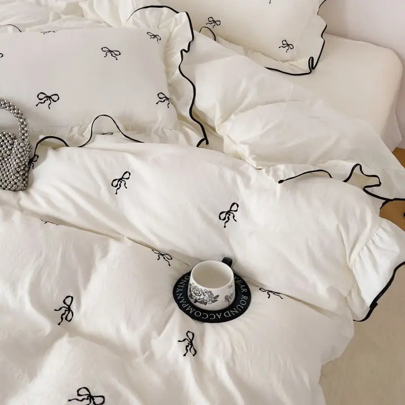 White bedding set featuring black bow embroidery and ruffled edges from the decorbites bow embroidery bedding set