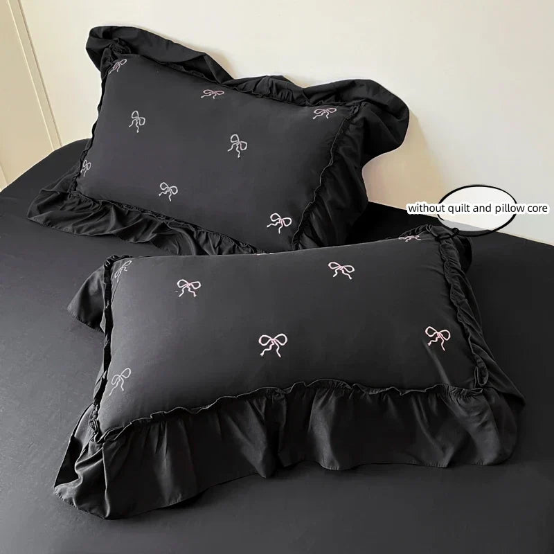 Black satin pillowcases with white bow embroidery and ruffled edges from decorbites bow embroidery bedding set