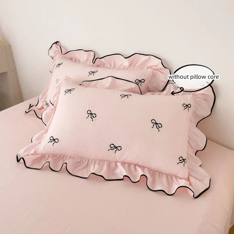 Pink pillowcases with black bow embroidery and ruffled edges from decorbites™ bow embroidery bedding set