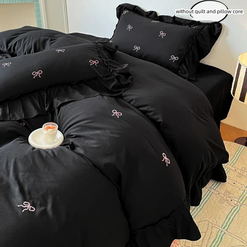 Black satin decorbites™ bow embroidery bedding set with delicate pink bows and ruffled edges for elegant decor