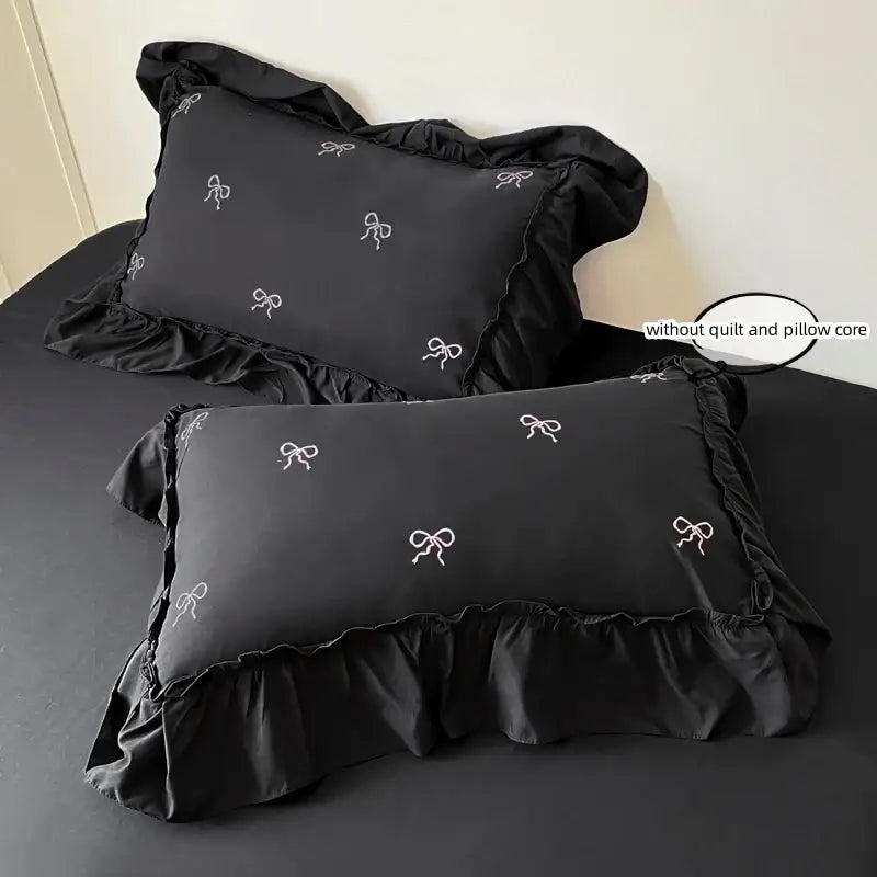 Black satin pillowcases with white bow embroidery and ruffled edges from decorbites bow embroidery bedding set