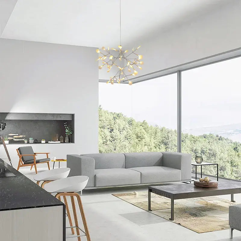 Modern gray fabric sofa with clean lines and minimalist design featuring a rose gold black branch design chandelier by decorbites