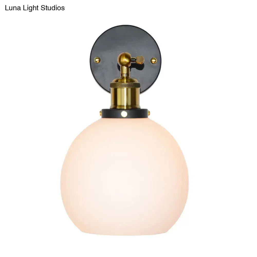 Industrial brass wall sconce featuring a sleek spherical frosted bubble white glass globe for bedroom lighting