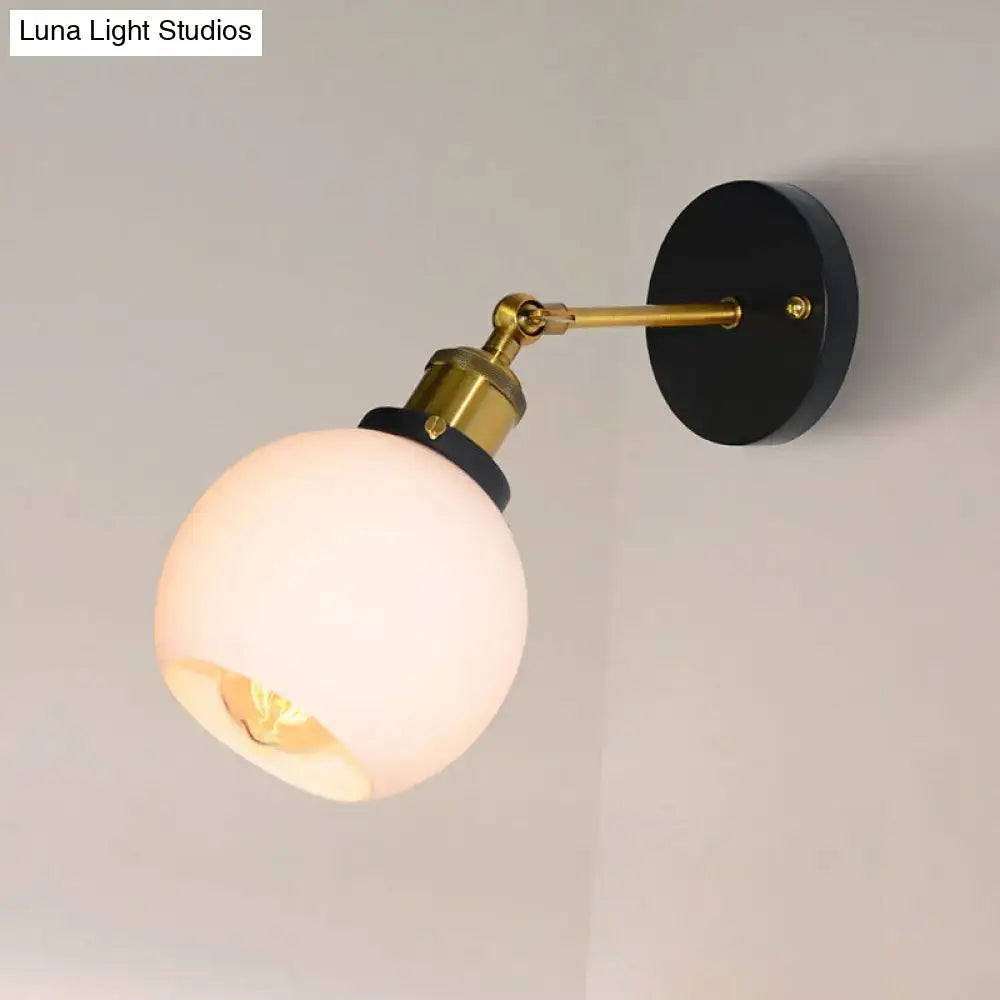 Industrial brass wall sconce with bubble white glass shade and matte black base for modern bedroom lighting