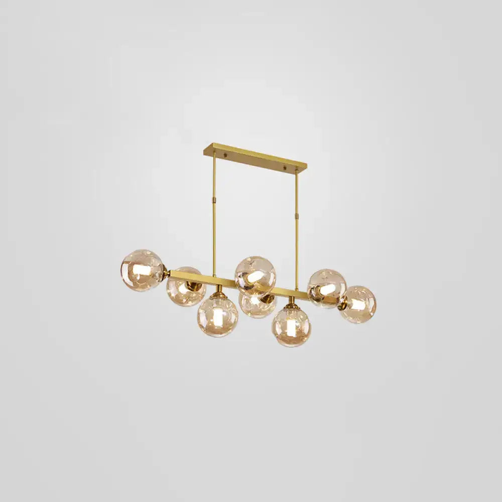 DecorBites™ bubbles glass pendant light features a gold-toned linear design with seven amber glass globe bulbs