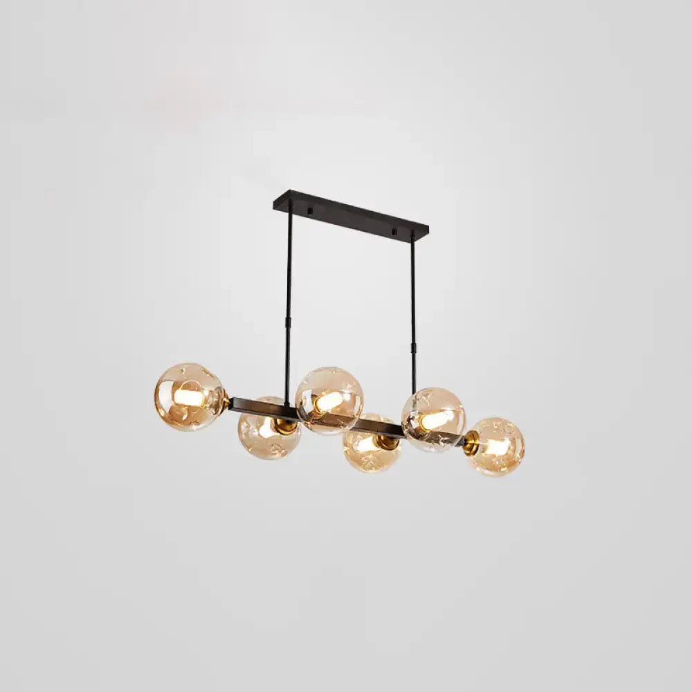 Modern black metal pendant light with five amber glass globe bulbs featuring stylish light features for dining