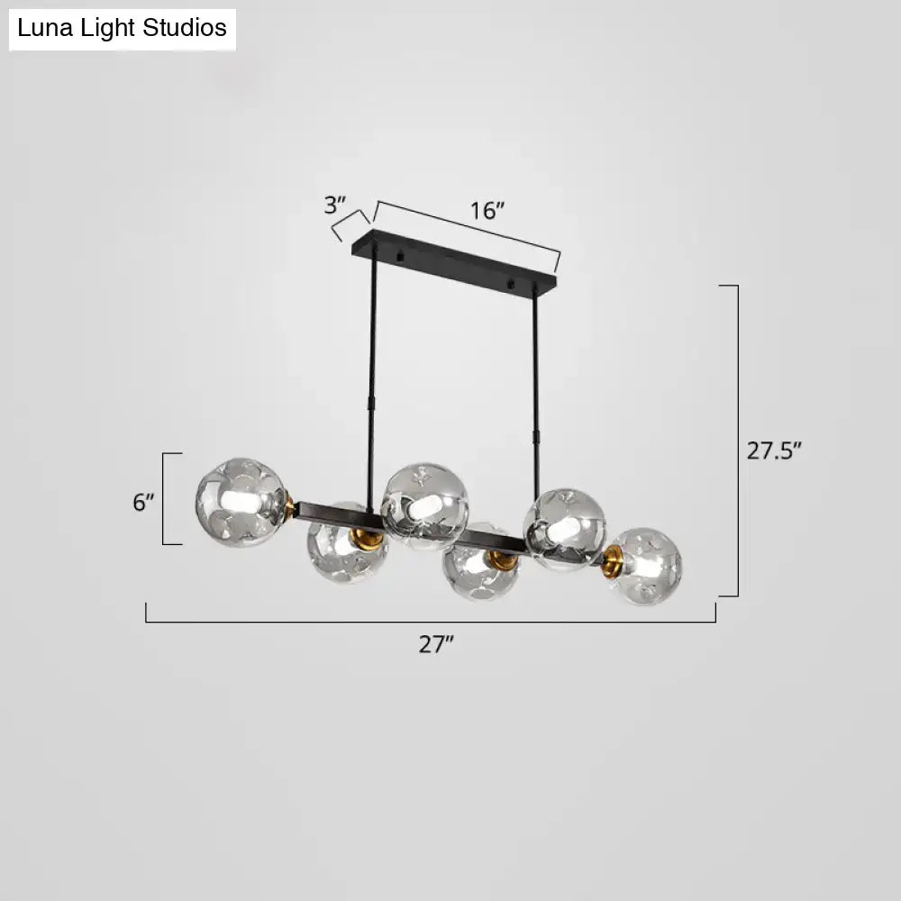 Modern black metal pendant light with five clear glass globe bulbs and gold-toned accents for stylish dining decor