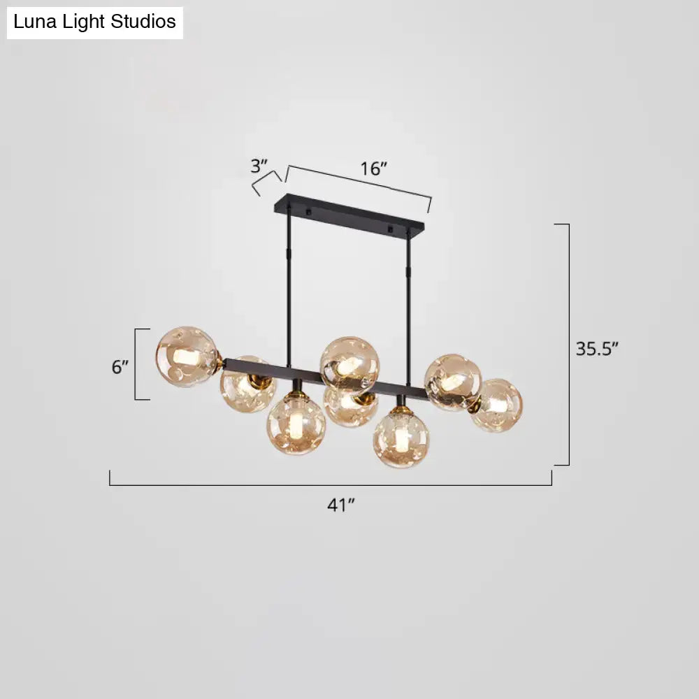 DecorBites™ bubbles glass pendant light features a modern black metal frame with seven amber glass globe bulbs for dining