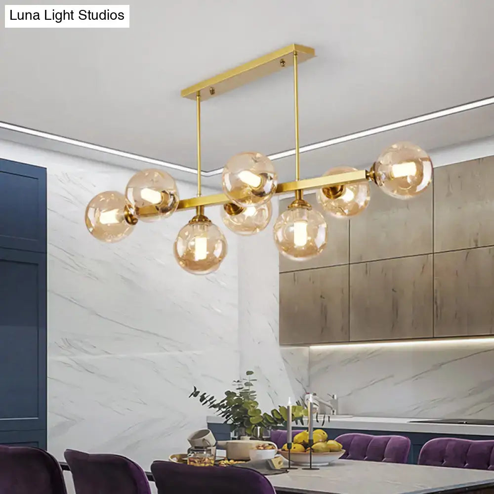 Gold-toned DecorBites™ Bubbles pendant light with amber glass globes featuring modern light features for dining islands