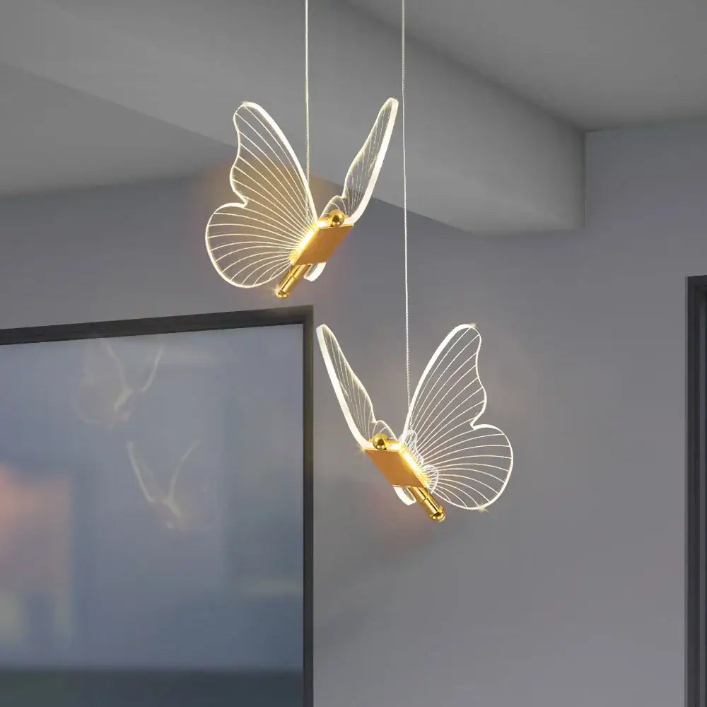 Two elegant translucent butterfly led pendant lights with gold metallic bodies and warm internal illumination by decorbites butterfly led