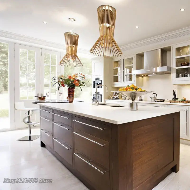 Dark wood kitchen island with white countertop and silver drawer handles under decorbites cage industrial pendant lights