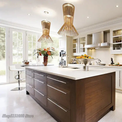 Dark wood kitchen island with white countertop and silver drawer handles under decorbites cage industrial pendant lights